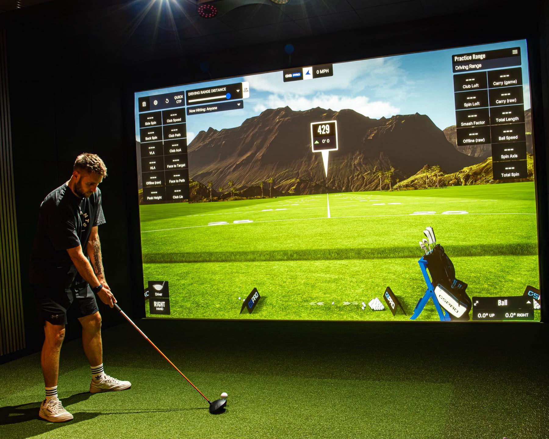 A golfer on the FlexTee simulator with shot data on screen